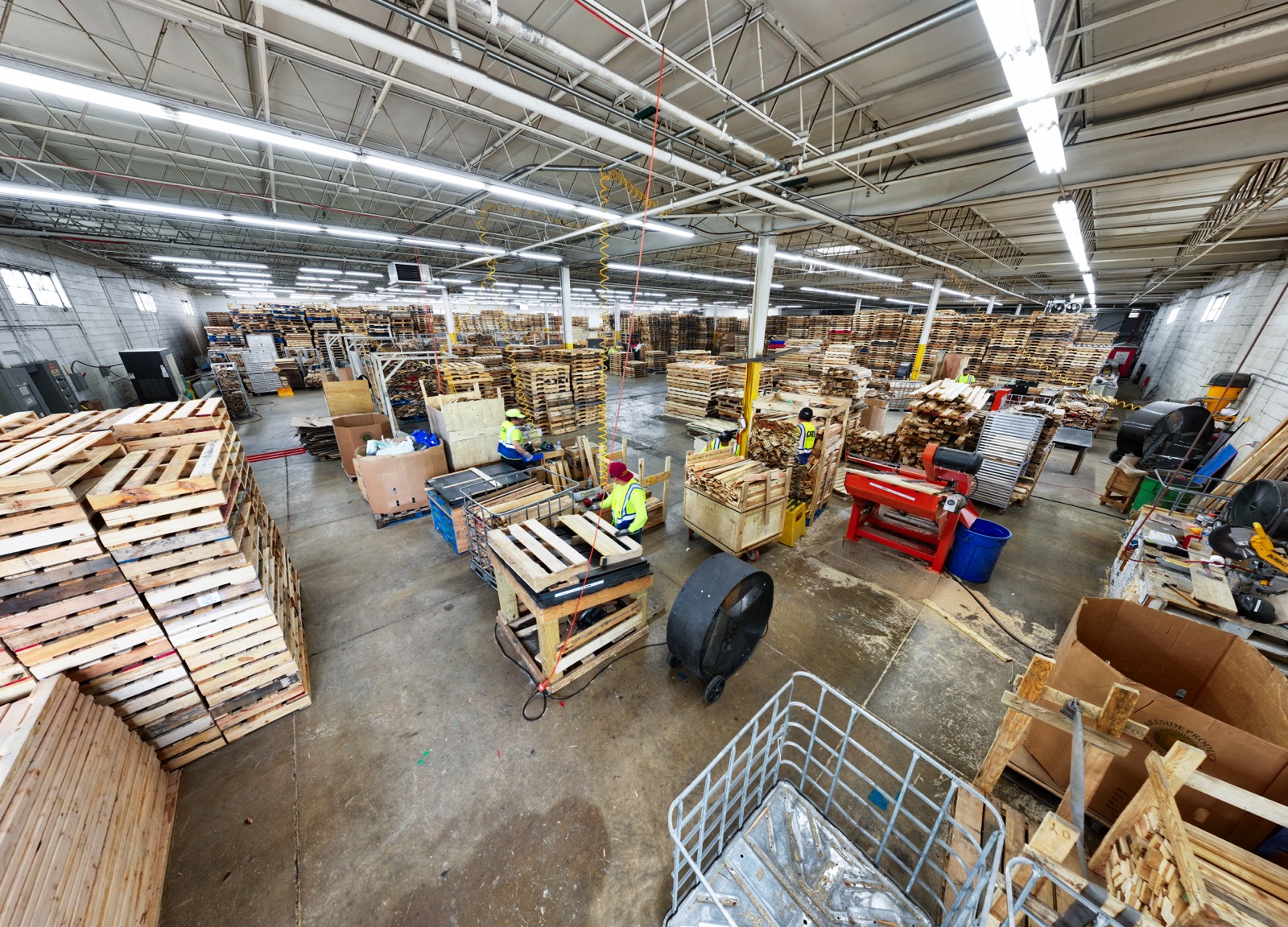 Inside the CRI Addison facility: pallet processing floor with crews, dismantlers, and stacked pallets