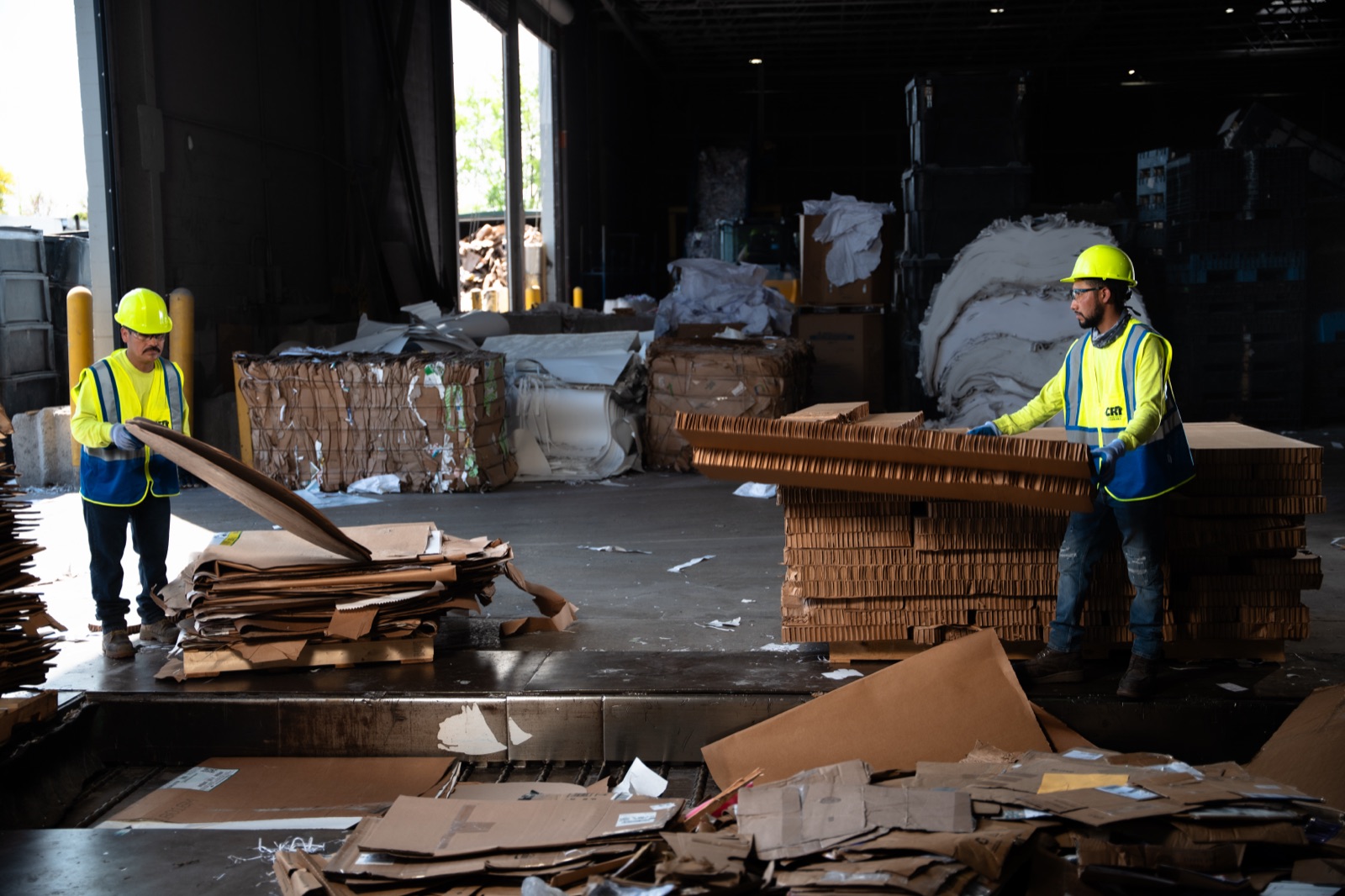 CRI on-site crew moving baled cardboard inside an Addison facility